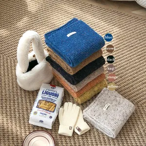 Accoglienti sciarpe invernali in maglia di vari colori vivaci con borsa soffice.