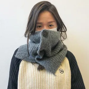 Detailansicht des grauen Strick-Halswärmers für Damen, kuscheliger Winterschal mit Knopf.