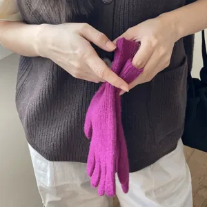 Primer plano de guantes táctiles de punto de lana magenta que muestran una textura muy suave.