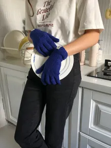 Primo piano di accoglienti guanti invernali in maglia blu con comodi polsini a coste.