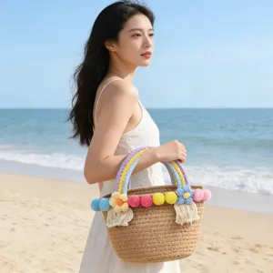 Woven straw beach handbag with colorful pom poms and cute flowers for summer vacation stylish