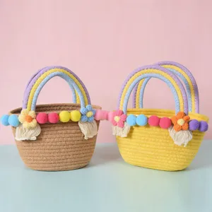 Woven cotton rope handbag with colorful pom poms and rainbow handles, stylish beach tote bag.