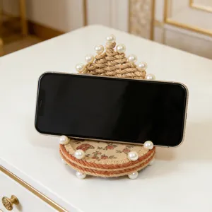 Soporte de teléfono móvil de cuerda de yute hecho a mano con perlas, detalle de decoración.