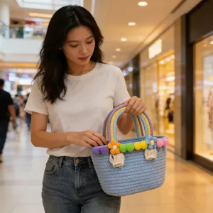 Handwoven cotton rope handbag with colorful pom-poms and flower decor for beach and daily.