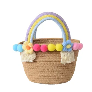 Cute woven straw handbag with colorful pom poms and rainbow handle for beach summer vacation