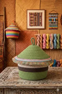 Close-up of handmade cotton woven storage basket featuring colorful tassels and lid for home decor.