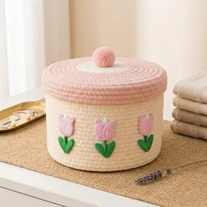Detailaufnahme des niedlichen Baumwollseil-Aufbewahrungskorbs mit rosa Tulpenstickerei und Deckel.