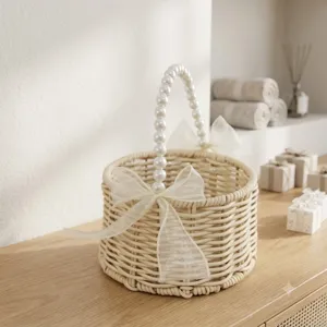 Woven rattan gift basket with pearl handle and organza bow detail for wedding flower display