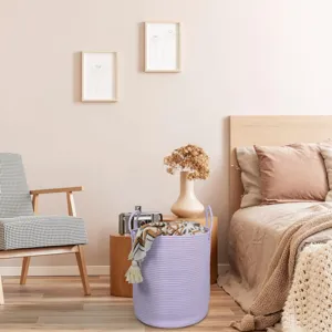 Cozy bedroom scene featuring a lavender woven cotton rope storage basket with dual handles.