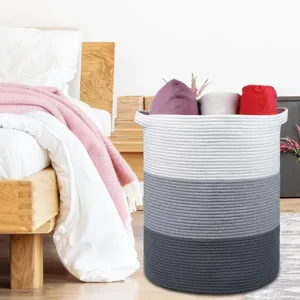 Vue détaillée du panier à linge en corde de coton tissé placé dans une chambre confortable.