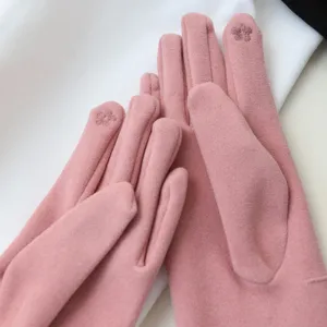 Close-up of women's pink velvet touchscreen gloves featuring delicate fingertip floral embroidery.