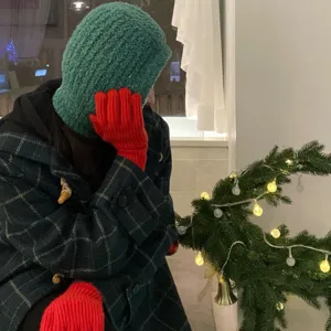 Green knitted balaclava hood detail, cozy winter ear protection and warm design for cold days.