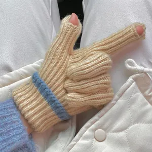 Detailed view of knit fingerless gloves, cozy ribbed blue stripe cuff, winter fashion accessory.