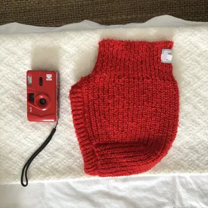 Red knitted balaclava hat for women, cozy winter warm earflap beanie cap detail view.