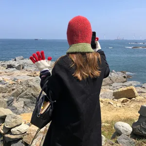 Cozy color-block knitted balaclava and warm winter gloves, stylish outdoor detail view.