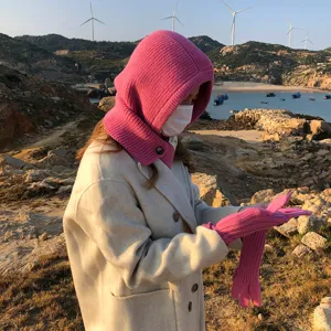 Detail van roze gebreide balaclava muts en handschoenen set, warme winteraccessoire.