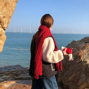 Gedetailleerd overzicht van een rode winter-gebreide sjaal, dik en warm design voor dames.