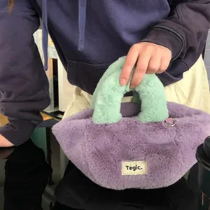 Detailed shot of a plush handbag featuring soft purple body and mint green handles close up.