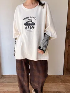 Primer plano detalle de guantes de medio dedo a rayas de estilo japonés con ropa casual.