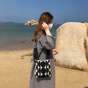 Sac à bandoulière en tricot avec motif géométrique noir et blanc pour le voyage de femmes.