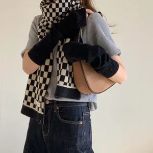 Chic black and white checkered knit scarf and arm warmers set, retro winter cozy fashion.