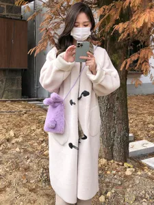 Gros plan d'un sac bandoulière pour téléphone en peluche lapin violet, doux et duveteux.