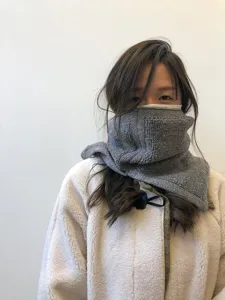 Primer plano detallado de un calentador de cuello de punto gris, accesorio de invierno.
