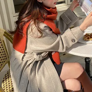 Gemütlicher oranger Woll-Strick-Schal Modedetailaufnahme für stilvolle Winteroutfits.