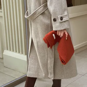 Klassischer Wollmantel kombiniert mit kuscheligem Strickschal für elegante Wintermode.