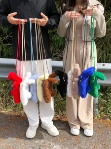 Sacs bandoulière téléphone lapin peluche multicolores en scène extérieure, vue détail.