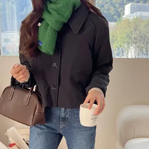 Cozy green knitted cross scarf for women and kids, stylish winter warmth fashion accessory.