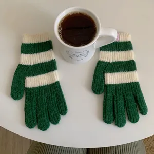 Groene en witte gestreepte gebreide winterhandschoenen detail, zacht warm wolmateriaal voor koud weer.