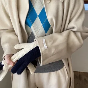 Detailed view of women's color-blocked knit gloves paired with winter outerwear outfits.