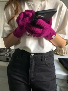 Primo piano dettagliato di comodi guanti touch screen in maglia magenta in scena.