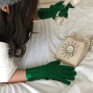Primer plano de guantes de punto verde de invierno con textura suave y cálida protección.