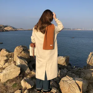 Vista detallada de una bufanda de punto naranja acogedora y cálida para el invierno.