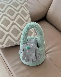 Détail de sac à main en peluche duveteuse avec texture douce et joli design hivernal.