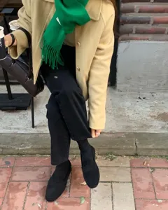 Primer plano de bufanda de lana con flecos verde brillante al aire libre, accesorio de moda.