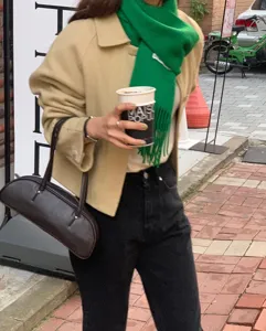 Elegante bufanda de lana verde con flecos combinada con atuendo casual para otoño e invierno.