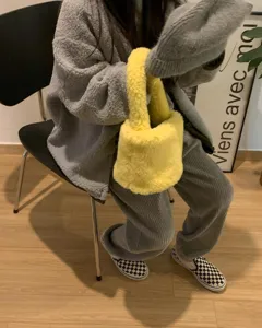Vue détaillée du joli sac à main en peluche jaune moelleux montrant sa texture douce et unique.