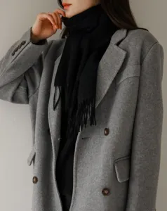 Detalle de bufanda de lana negra clásica con flecos, accesorio de invierno cálido uso diario.