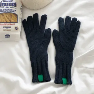 Detalle de guantes de punto azul oscuro, accesorio de lana cálida de invierno de color sólido dividido.