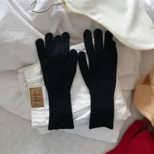 Primer plano detallado de la textura de guantes negros de punto táctiles sobre fondo.