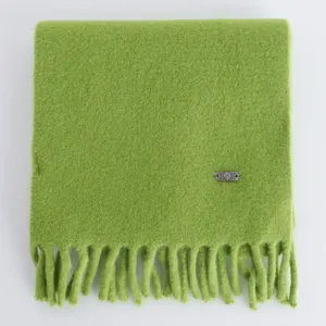 Primo piano dettaglio di sciarpa invernale lavorata a maglia verde morbida, calda.