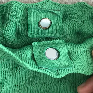 Gedetailleerd overzicht van de groene gebreide tas met magnetische sluiting van topkwaliteit.