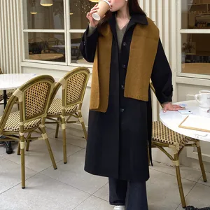 Detailaufnahme von stilvollem Wollschal und Mantel im gemütlichen Café-Szenen-Look.
