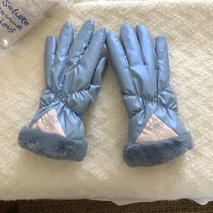 Detail view of light blue windproof winter gloves with plush grey cuffs and embroidered accent.