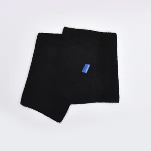 Black knitted cross scarf detail view, warm winter neck warmer with cute blue brand label.