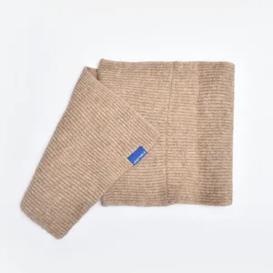 Detail view of the soft knitted warm cross neck scarf in solid color with a small tag.
