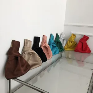 Nahaufnahme bunter japanischer Satin-Knotentaschen, ordentlich auf einem Glastisch platziert.